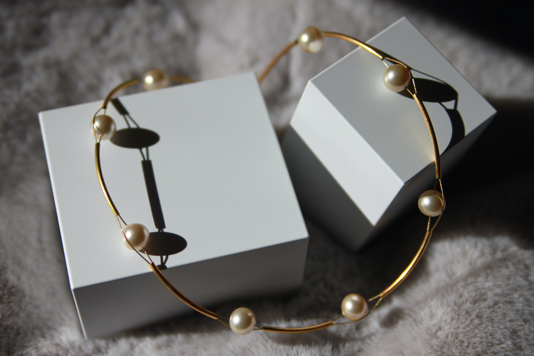 Halskette, Perlen getrennt durch goldfarbene Röhrchen